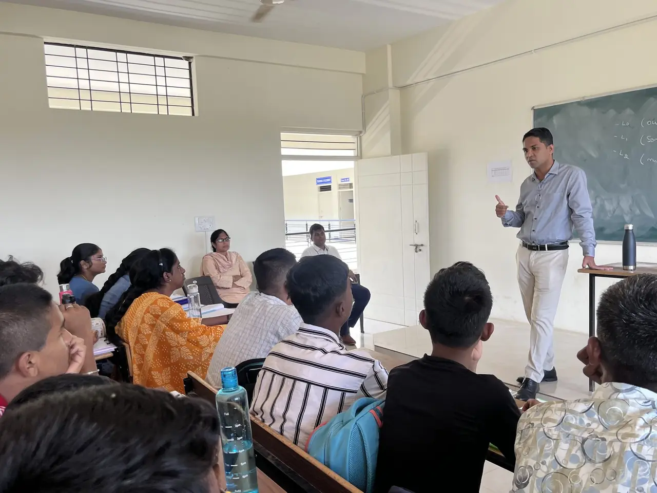 Teacher explaining a concept to a large NEET batch in a lecture hall